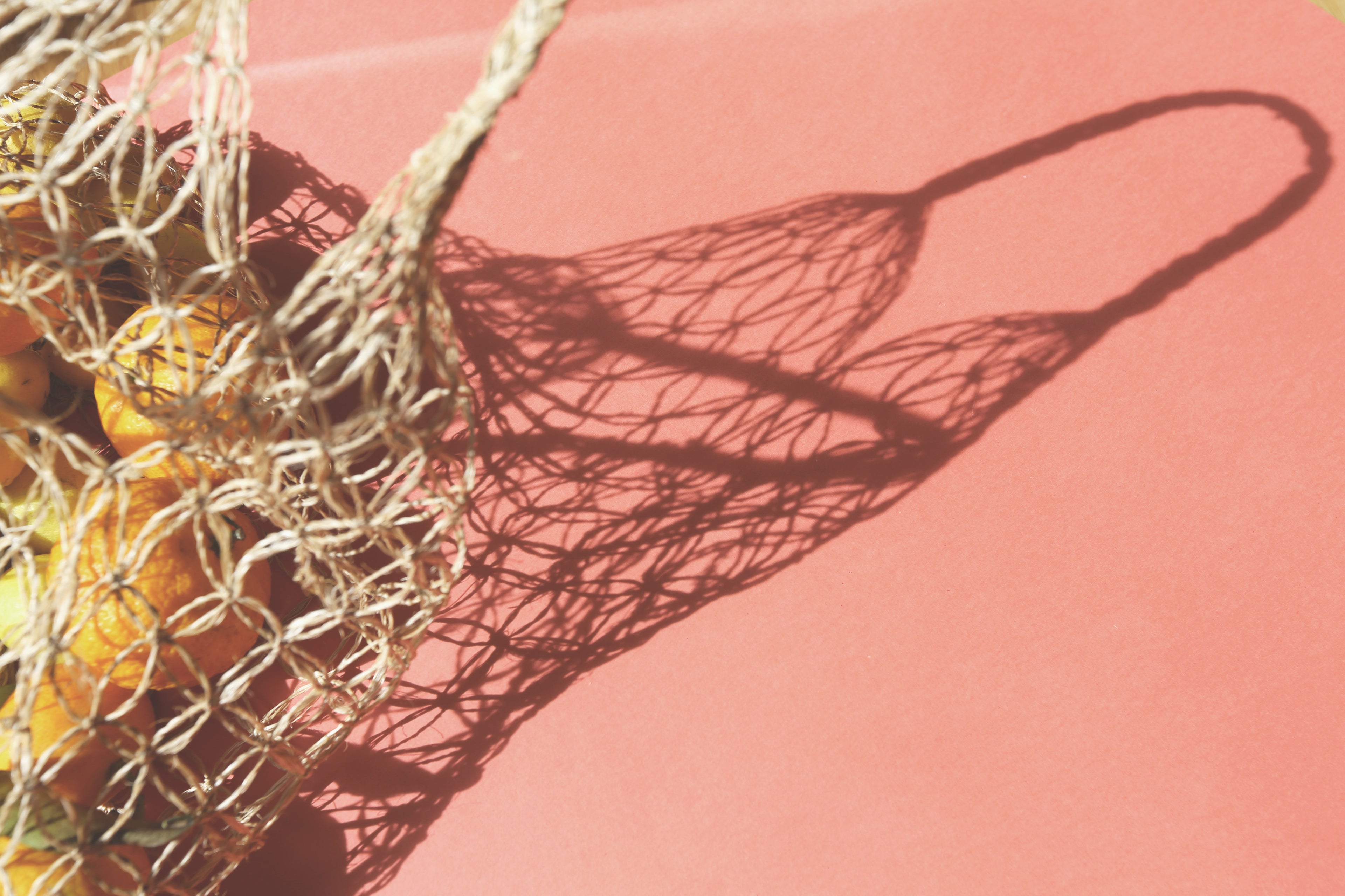 Decorative fishing net with shadow on a pink background